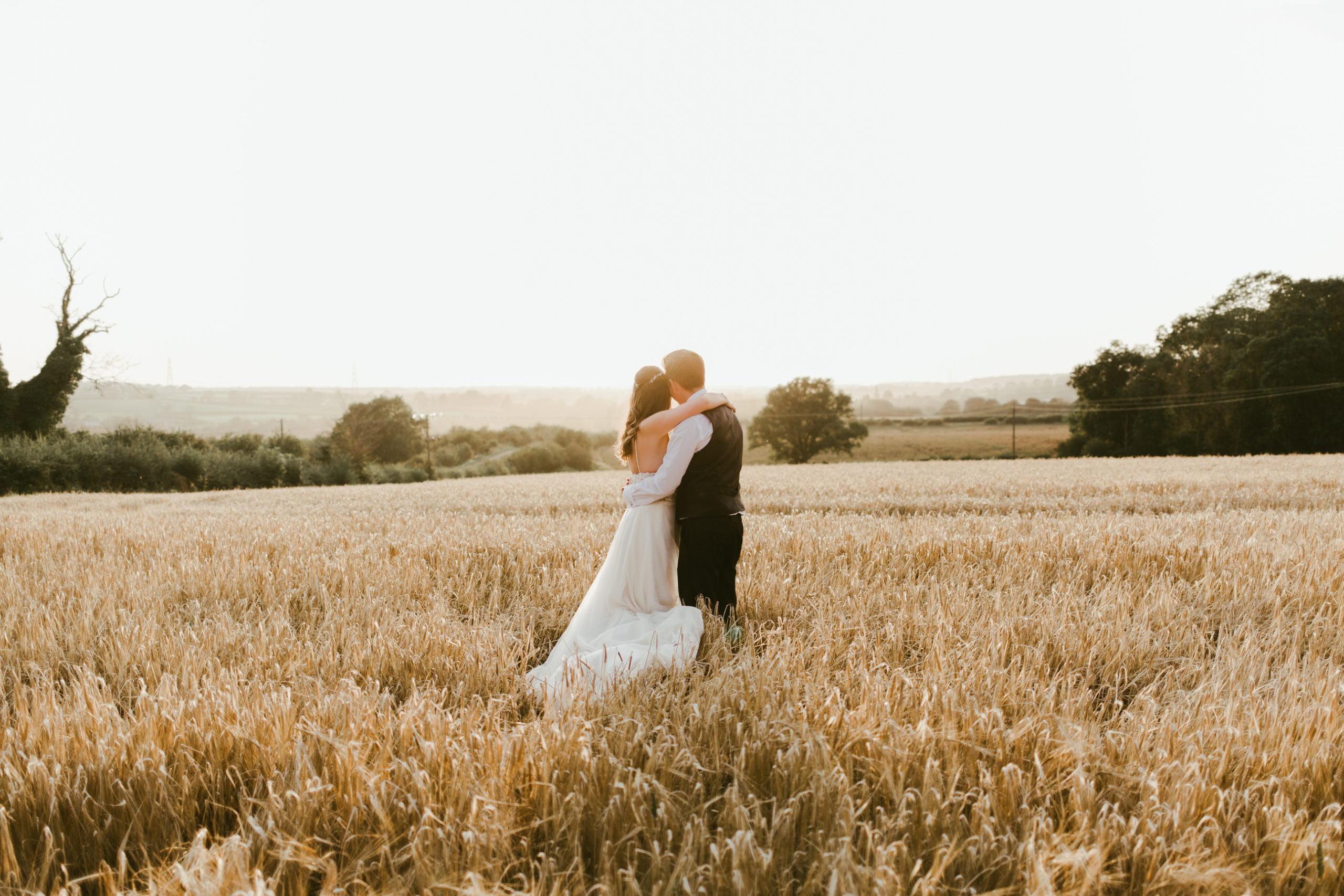 summer back garden marquee wedding bride and groom cornfield at sunset